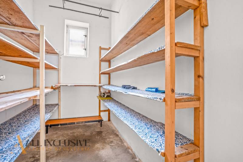 REZERVOVANÉ 3-IZBOVÝ RD NA PRIESTRANNOM POZEMKU, VRAKÚ - Skladací priestor v rodinnom dome s drevenými policami a malým oknom.