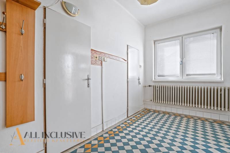 REZERVOVANÉ 3-IZBOVÝ RD NA PRIESTRANNOM POZEMKU, VRAKÚ - Chodba rodinného domu s dlaždicovou podlahou, bielymi dverami a vešiakom.