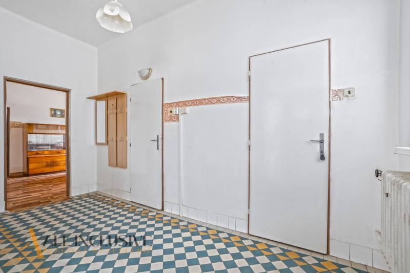 REZERVOVANÉ 3-IZBOVÝ RD NA PRIESTRANNOM POZEMKU, VRAKÚ - Chodba v rodinnom dome s farebnou dlažbou a dreveným nábytkom.