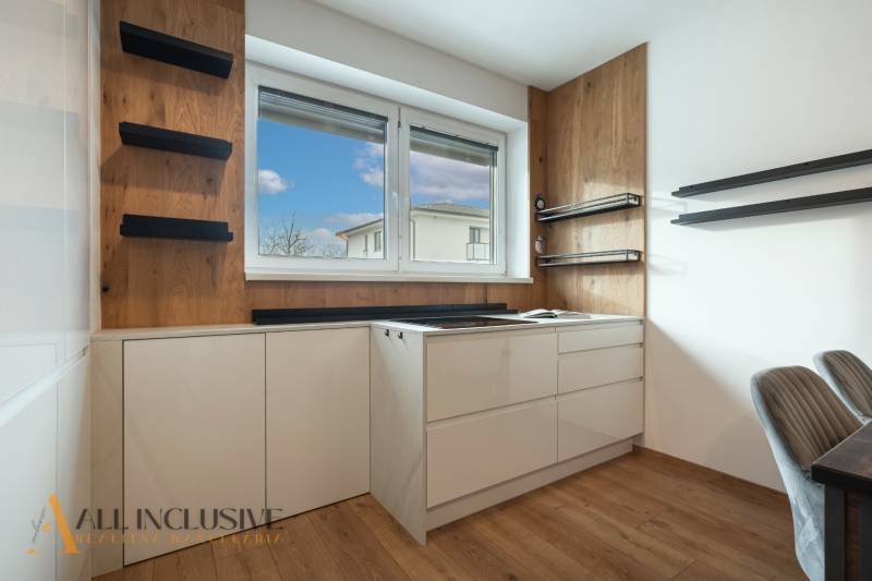 Rezervované 3-izbový byt so záhradou, Šamorín - Kuchyňa v 3-izbovom byte, biele skrinky, podlaha s dreveným dekorom, okno s výhľadom.