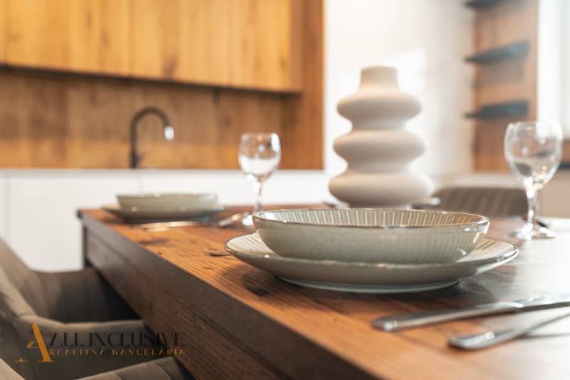 Rezervované 3-izbový byt so záhradou, Šamorín - Jedálenský stôl v 3-izbovom byte s drevenými detailmi a jemným porcelánom.