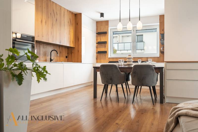 Rezervované 3-izbový byt so záhradou, Šamorín - Kuchyňa v 3-izbovom byte, s podlahou s dreveným dekorom a štýlovým jedálenským stolom.