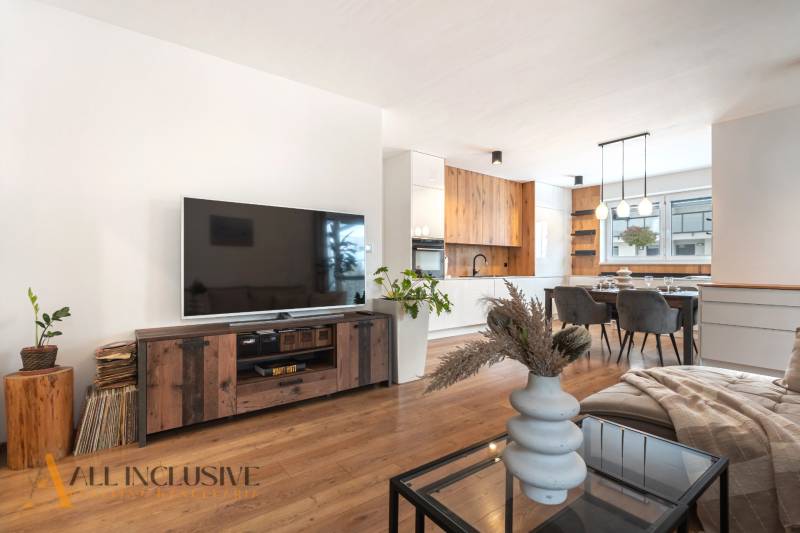 Rezervované 3-izbový byt so záhradou, Šamorín - Svetlá obývačka v 3-izbovom byte s podlahou s dreveným dekorom, moderným nábytkom a televízorom.