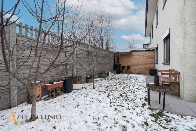 Rezervované 3-izbový byt so záhradou, Šamorín - Záhrada 3-izbového bytu na Kráľoviankach v Šamoríne s drevenou lavičkou a snehovým pokryvím.