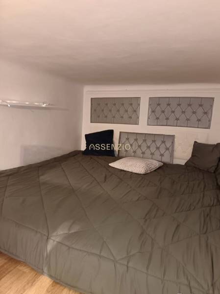 – PRENAJOM – 3 IZBOVÝ BYT – STARE MESTO  - Spálňa v 3-izbovom byte s nízkym stropom, pukovými panelmi na stene a podlahou s dreveným dekorom.