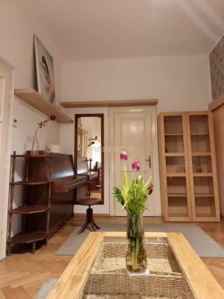 – PRENAJOM – 3 IZBOVÝ BYT – STARE MESTO  - Interiér 3-izbového bytu so stolom, vázou s kvetmi a dreveným dekorom podlahy.