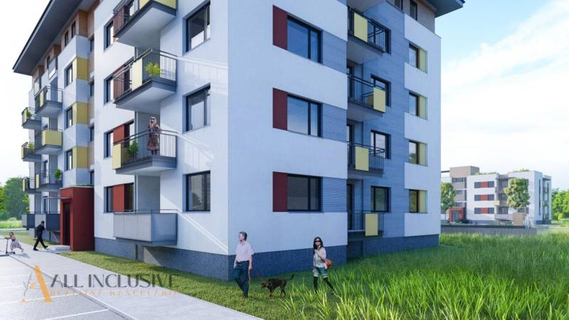 NA PREDAJ 3 IZBOVÉ BYTY DUNAJSKÁ STREDA - Bytový dom na ulici Júliusa Lőrincza, s balkónmi, ľudia prechádzajúci sa po okolí.