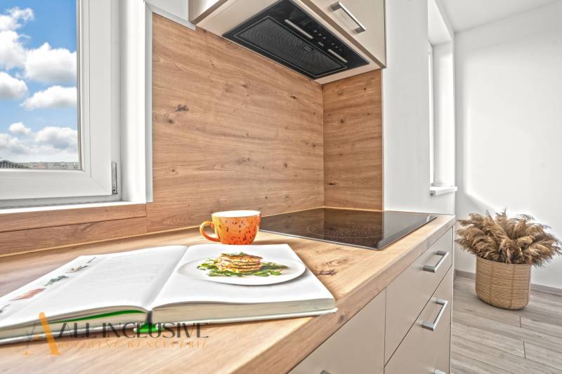 NA PRENÁJOM 3-IZB BYT S BALKÓNOM A ZÁHRADOU,DUN.STREDA - Kuchyňa s podlahou s dreveným dekorom v 3-izbovom byte. V popredí oranžový hrnček.