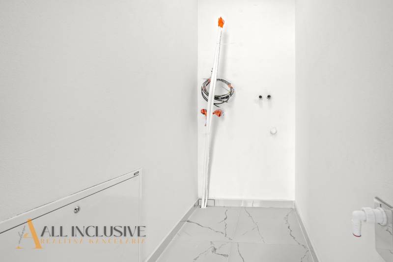 NA PRENÁJOM 3-IZB BYT S BALKÓNOM A ZÁHRADOU,DUN.STREDA - Úzka miestnosť s bielymi stenami a lesklou podlahou v 3-izbovom byte.