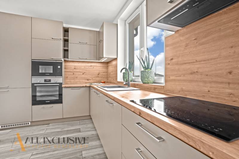 NA PRENÁJOM 3-IZB BYT S BALKÓNOM A ZÁHRADOU,DUN.STREDA - Kuchyňa v 3-izbovom byte s podlahou s dreveným dekorom a veľkým oknom.