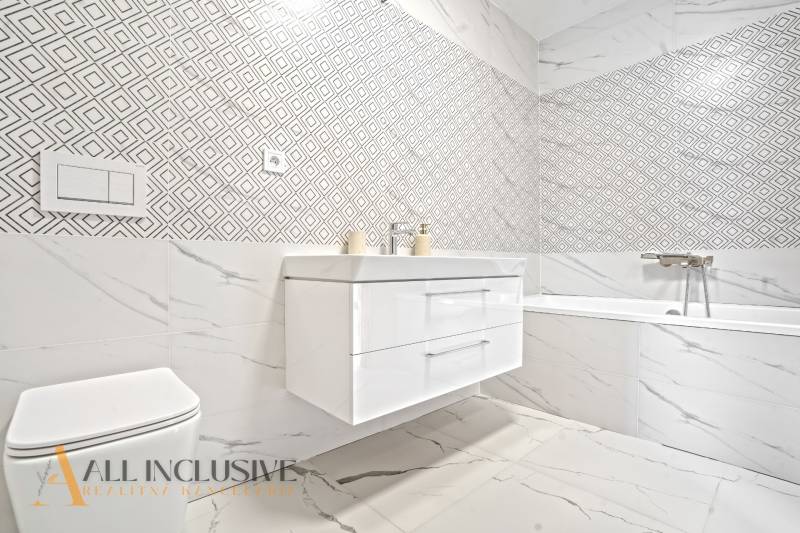 NA PRENÁJOM 3-IZB BYT S BALKÓNOM A ZÁHRADOU,DUN.STREDA - Elegantná kúpeľňa v 3-izbovom byte so vzorovanými obkladmi a vaňou.