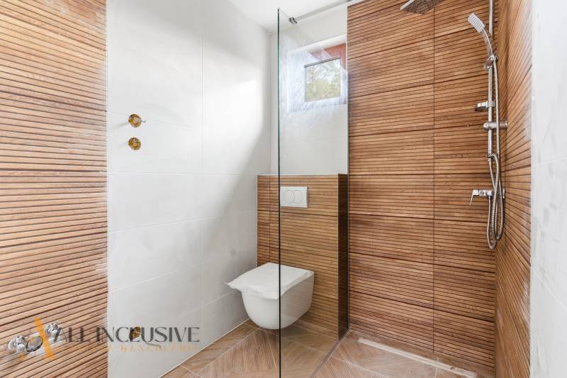 NA PREDAJ 4-IZBOVÉ RD – REZIDENČNÝ PROJEKT, GABČÍKOVO - Sprchový kút a závesná toaleta s obkladom s dreveným dekorom v rodinnom dome.