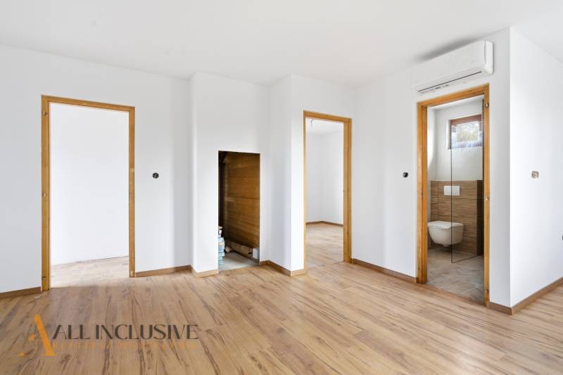 NA PREDAJ 4-IZBOVÉ RD – REZIDENČNÝ PROJEKT, GABČÍKOVO - Interiér rodinného domu s podlahou s dreveným dekorom, viditeľné sú dvere do kúpeľne.