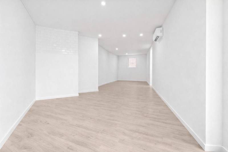 NA PREDAJ NEBYTOVÝ PRIESTOR V DUNAJSKEJ STREDE - Svetlý obchodný priestor s podlahou s dreveným dekorom a bielymi stenami.