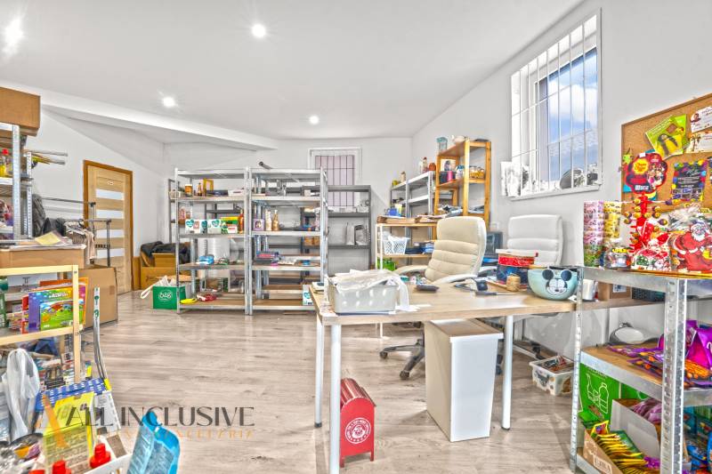 NA PREDAJ NEBYTOVÝ PRIESTOR V DUNAJSKEJ STREDE - Obchodné priestory s regálmi a produktmi, podlaha s dreveným dekorom, svetlá miestnosť.