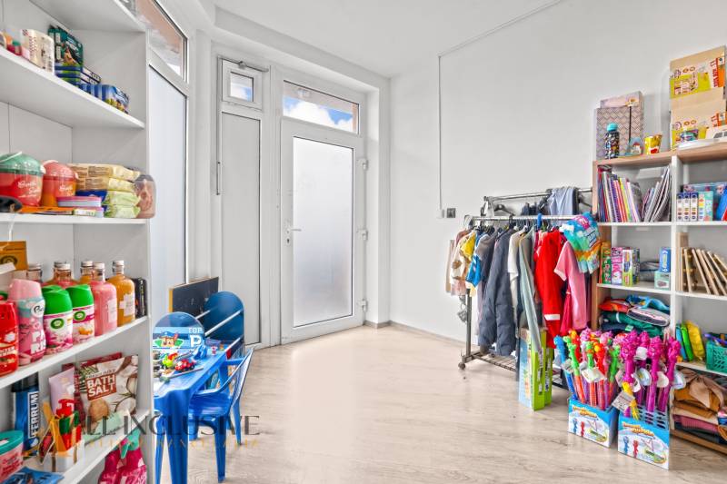 NA PREDAJ NEBYTOVÝ PRIESTOR V DUNAJSKEJ STREDE - Obchodné priestory s tovarom na policiach a podlahou s dreveným dekorom.