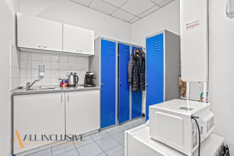 NA PRENÁJOM OBCHODNÝ PRIESTOR V DUNAJSKEJ STREDE - Obchodné priestory s modrými skrinkami, kuchynskou linkou a spotrebičmi, káva na stole.