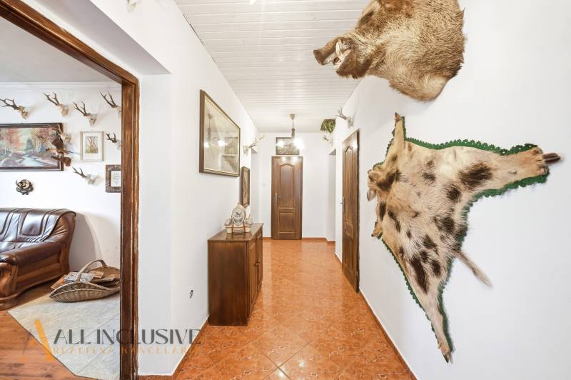 Na predaj 3-izbový rodinný dom, Topoľníky - Interiér rodinného domu s rustikálnym dekorom a poľovníckymi trofejami na stenách.