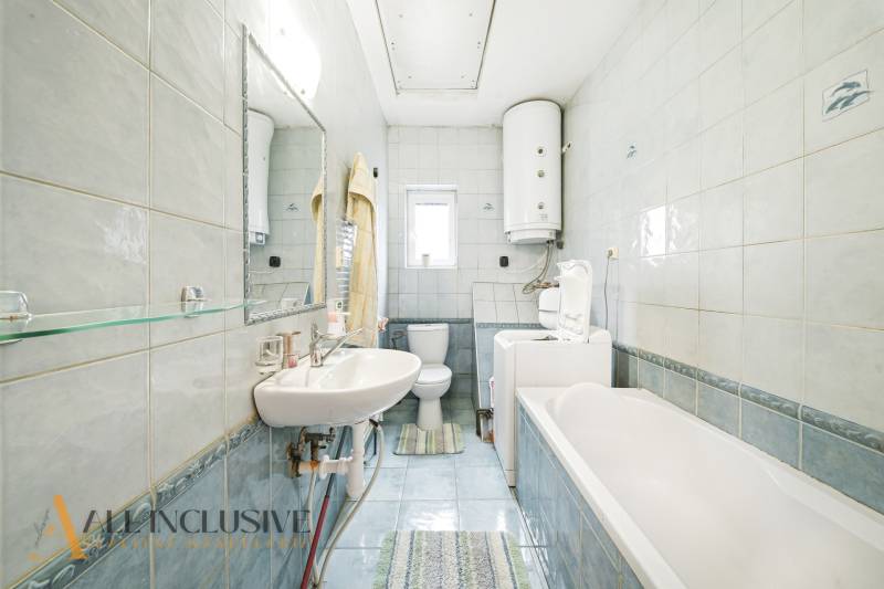 Na predaj 3-izbový rodinný dom, Topoľníky - Kúpeľňa s bielymi obkladačkami, vaňou a práčkou v rodinnom dome.