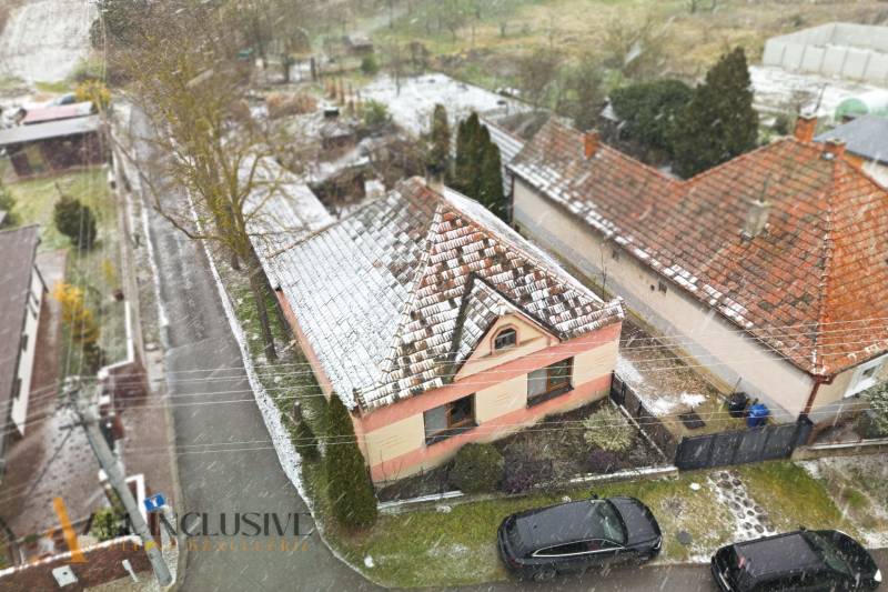 Na predaj 3-izbový rodinný dom, Topoľníky - Rodinný dom v Topoľníkoch pokrytý snehom, so záhradou a zasneženou strechou.