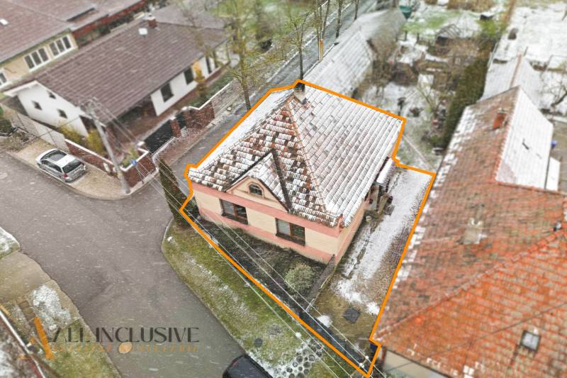 Na predaj 3-izbový rodinný dom, Topoľníky - Rodinný dom v Topoľníkoch so zasneženou strechou a ohraničeným pozemkom z leteckého pohľadu.