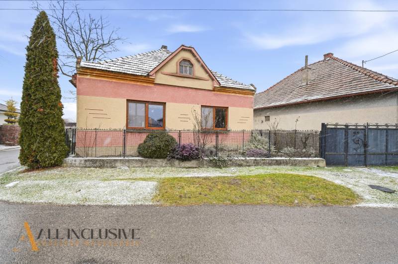 Na predaj 3-izbový rodinný dom, Topoľníky - Rodinný dom v Topoľníkoch s farebnou fasádou, záhradou a zasneženou strechou.