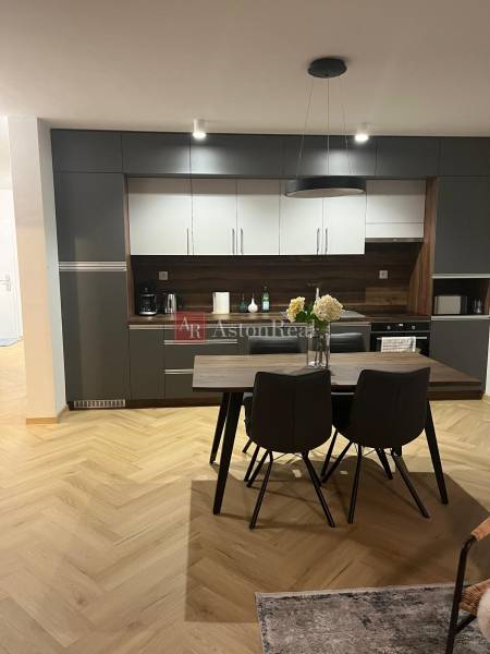 EXKLUZÍVNE-PREDAJ 3-IZBOVÝ BYT POPRAD, širšie centrum 80 m2 s gar.st. - Kuchyňa v 3-izbovom byte so sivými skrinkami a podlahou s dreveným dekorom.