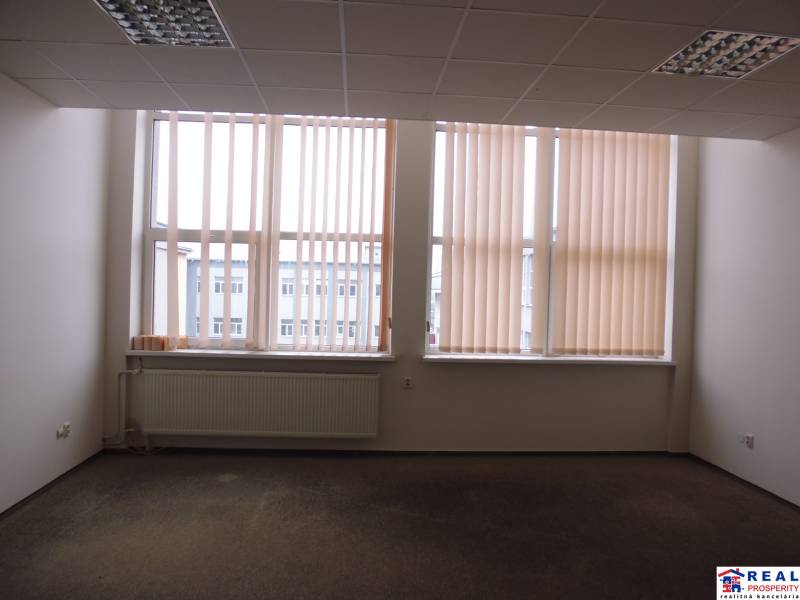 MASARYKOVA: Nebytové priestory 30 m2 - 3.posch., VÝŤAH, parkovanie - Kancelária s veľkým oknom, žalúziami a podlahou s dreveným dekorom.