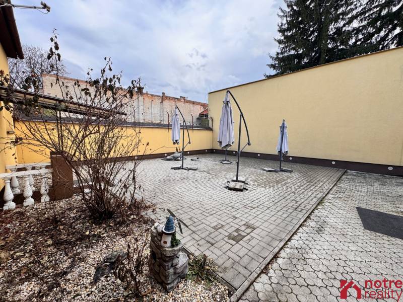 Podnikateľský objekt na prenájom v Lučenci - V centre Lučenca je dlaždený dvor s slnečníkmi pre gastro priestory.