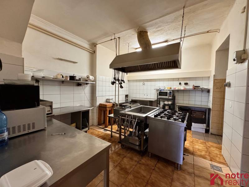 Podnikateľský objekt na prenájom v Lučenci - Kuchyňa v gastro priestoroch so spotrebičmi a nerezovými pracovnými povrchmi, obkladané steny.