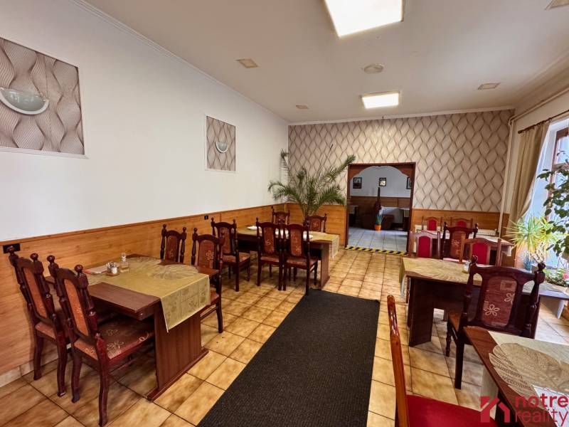 Podnikateľský objekt na prenájom v Lučenci - Gastro priestory s dreveným dekorom, dekoratívnou výzdobou a stolmi pre hostí.