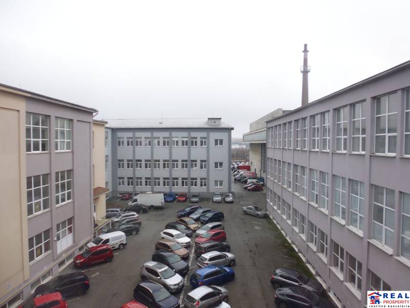 MASARYKOVA: Nebytové priestory 36 m2 - 3.posch., VÝŤAH, parkovanie - Budovy kancelárií na Masarykovej ulici v Prešove s množstvom zaparkovaných áut na dvore.