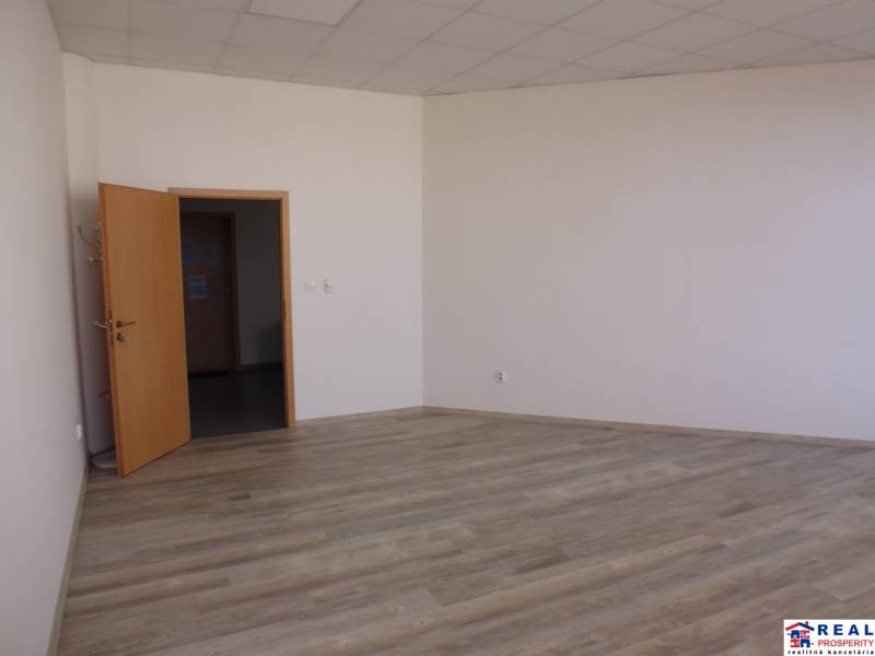MASARYKOVA: Nebytové priestory 36 m2 - 3.posch., VÝŤAH, parkovanie - V kancelárii s podlahou s dreveným dekorom sú biele steny a otvorené dvere.
