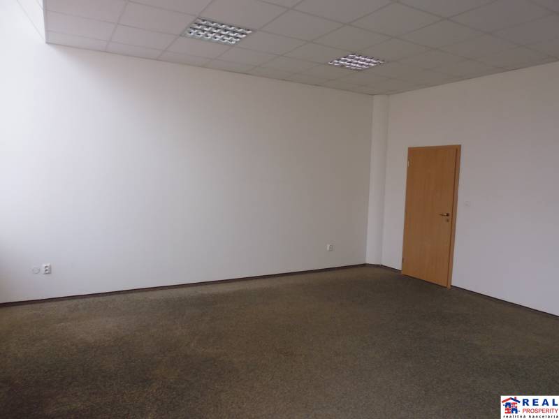 MASARYKOVA: Nebytové priestory 36 m2 - 3.posch., VÝŤAH, parkovanie - Kancelária s kobercovou podlahou, biele steny, drevené dvere; jednoduchý dizajn.