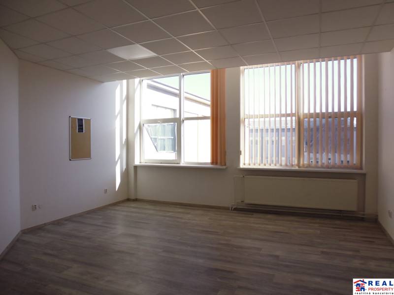 MASARYKOVA: Nebytové priestory 36 m2 - 3.posch., VÝŤAH, parkovanie - Interiér kancelárie s podlahou s dreveným dekorom, veľké okná a radiátor.