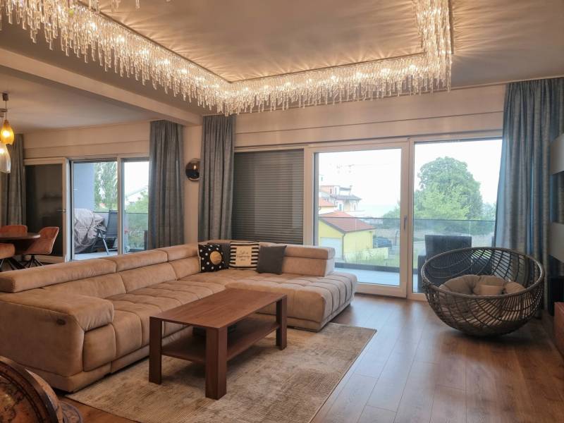 CHORVÁTSKO - Luxusne zariadený 3 izbový apartmán - VRSI, Zadar - Obývacia izba s pohodlnou sedačkou, krištáľovými svietidlami a podlahou s dreveným dekorom.