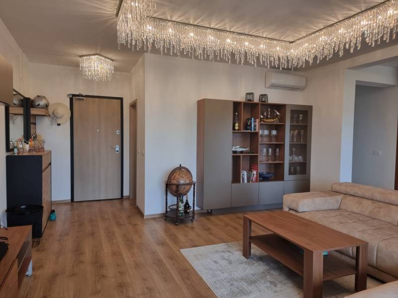 CHORVÁTSKO - Luxusne zariadený 3 izbový apartmán - VRSI, Zadar - Obývačka v 3-izbovom byte s podlahou s dreveným dekorom, pohovkou a skriňou.