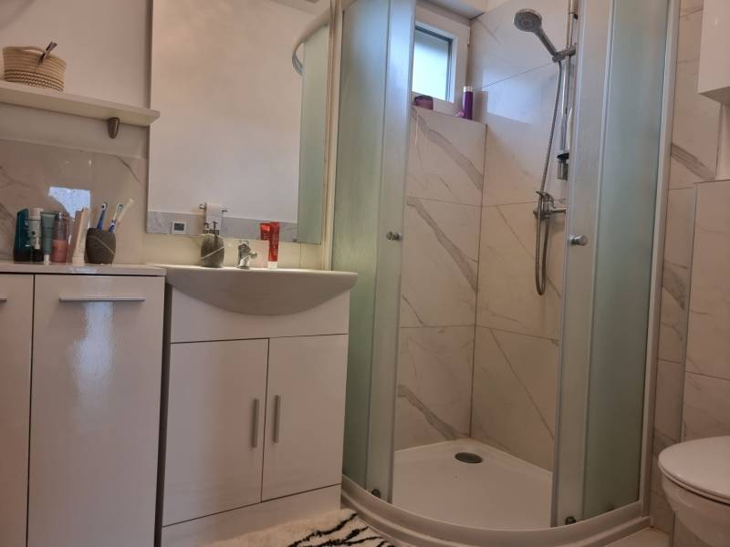 CHORVÁTSKO - Luxusne zariadený 3 izbový apartmán - VRSI, Zadar - Kúpeľňa v 3-izbovom byte s umývadlom, sprchovacím kútom a skrinkami na uloženie.