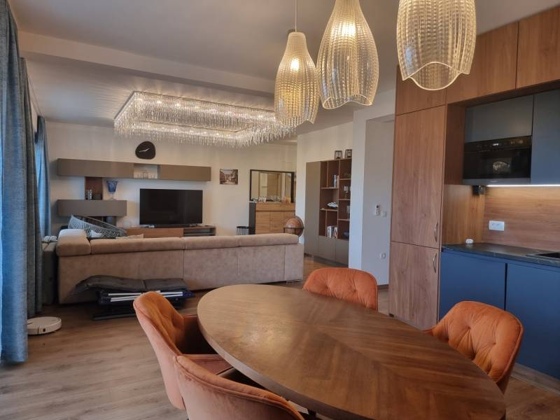 CHORVÁTSKO - Luxusne zariadený 3 izbový apartmán - VRSI, Zadar - Obývacia izba v 3-izbovom byte s podlahou s dreveným dekorom a závesnými svietidlami.