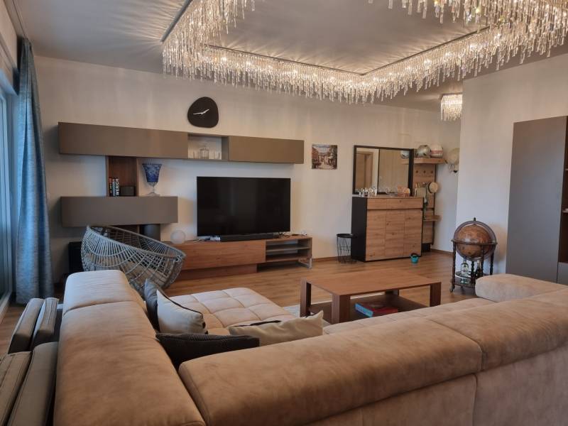 CHORVÁTSKO - Luxusne zariadený 3 izbový apartmán - VRSI, Zadar - Obývacia izba v 3-izbovom byte s podlahou s dreveným dekorom a štýlovým lustrom.