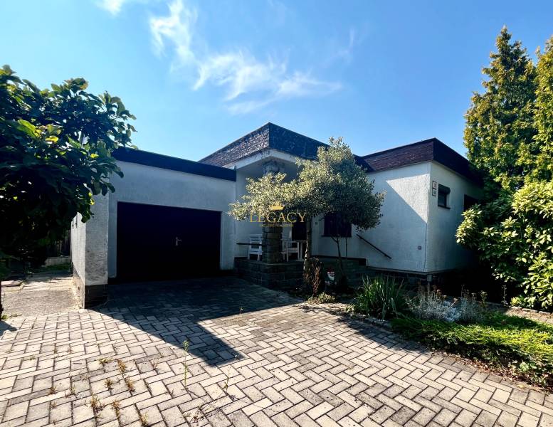 RD 4 izbový na veľkorysom pozemku, Ivanka pri Dunaji - Rodinný dom v Ivanke pri Dunaji s garážou a kvetinovým záhonom, na dláždenom chodníku.