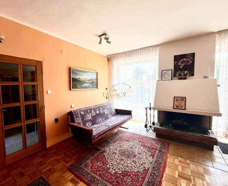 RD 4 izbový na veľkorysom pozemku, Ivanka pri Dunaji - Obývacia izba v rodinnom dome s krbom, pohovkou a podlahou s dreveným dekorom.