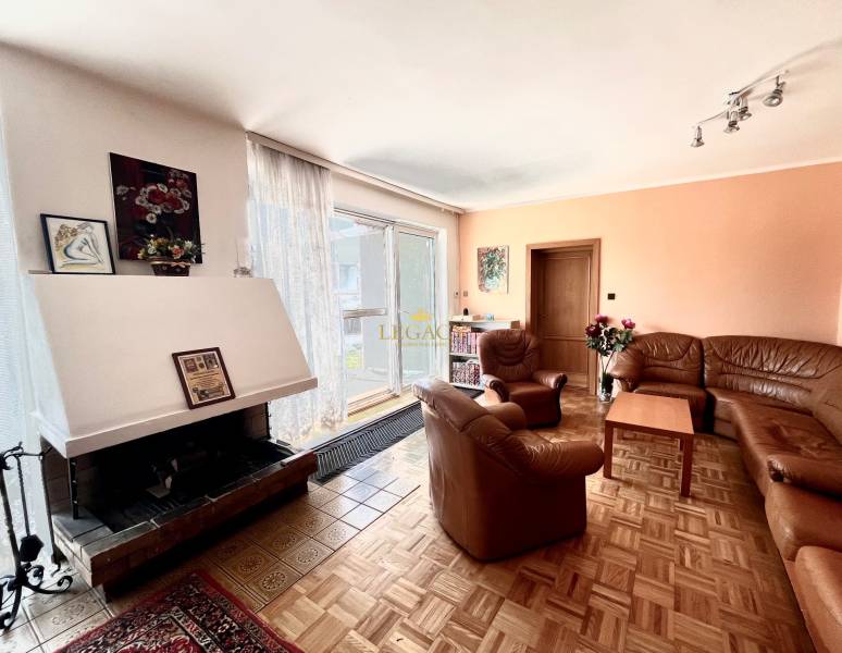 RD 4 izbový na veľkorysom pozemku, Ivanka pri Dunaji - Rodinný dom s krbom, pohovkami, obrázkami na stene a podlahou s dreveným dekorom.