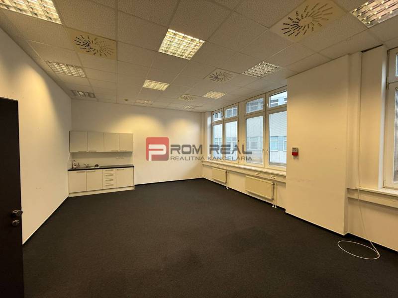 Skvelá ponuka kancelária 60 m2 v centre Bratislavy - V kancelárii sú biele skrinky, koberce, stropné svietidlá a veľké okná.