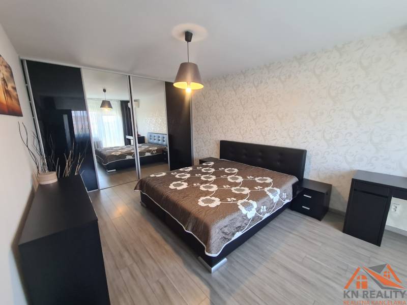 Reprezentatívny 2 izb.byt na prenájom SOHO TOWER Komárno ! - Spálňa v 2-izbovom byte s veľkou posteľou a podlahou s dreveným dekorom.