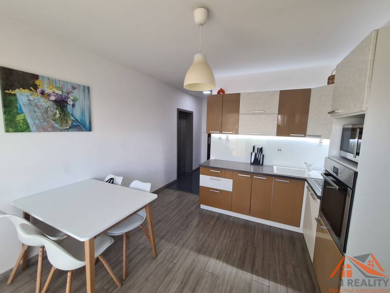 Reprezentatívny 2 izb.byt na prenájom SOHO TOWER Komárno ! - Kuchyňa v 2-izbovom byte s podlahou s dreveným dekorom a jedálenským stolom.