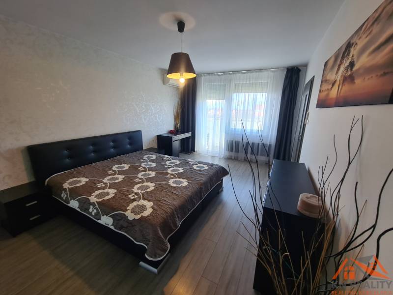 Reprezentatívny 2 izb.byt na prenájom SOHO TOWER Komárno ! - Spálňa v 2-izbovom byte s posteľou, skrinkou a podlahou s dreveným dekorom.