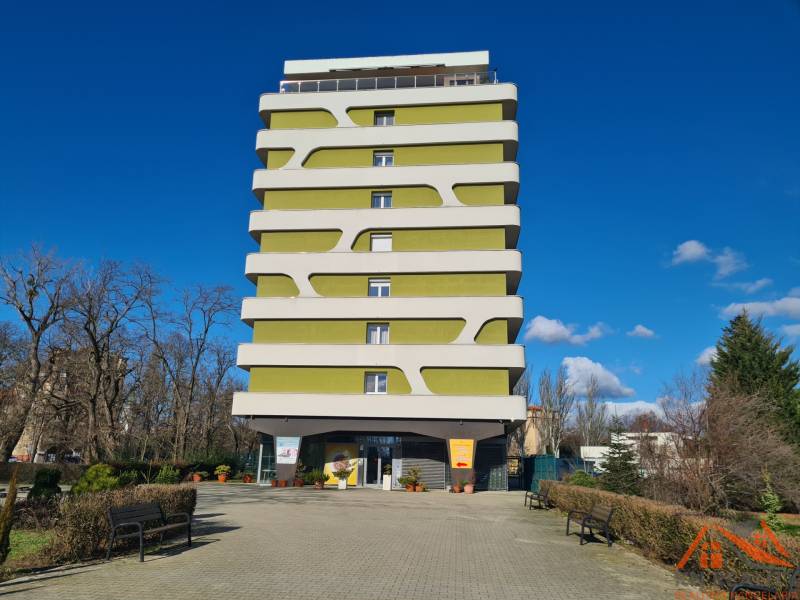 Reprezentatívny 2 izb.byt na prenájom SOHO TOWER Komárno ! - Viacposchodový bytový dom v Komárne s moderným dizajnom, obklopený zeleňou a lavičkami.