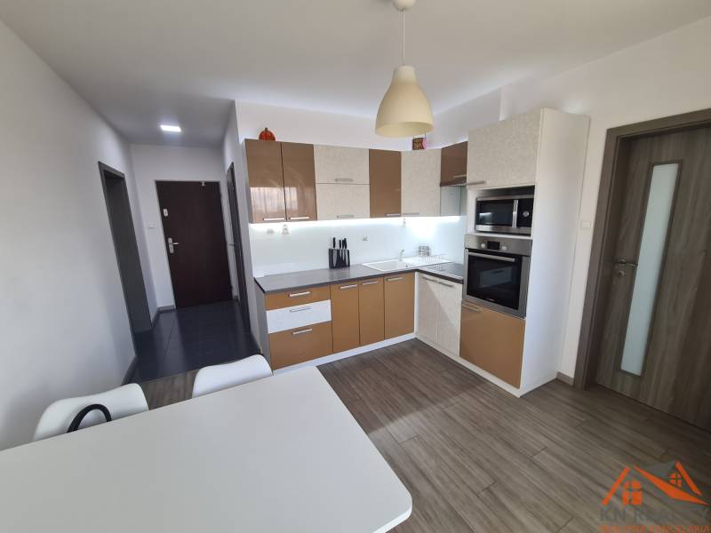 Reprezentatívny 2 izb.byt na prenájom SOHO TOWER Komárno ! - Kuchyňa so spotrebičmi a stolom, podlaha s dreveným dekorom v 2-izbovom byte.