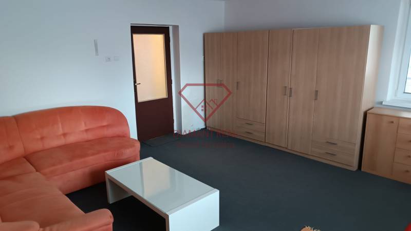 Na predaj RD na bývanie alebo investičná príležitosť Horné Saliby - Obývačka v rodinnom dome so sedačkou, stolíkom a skriňou na mieru.